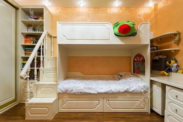 Пространство небольшой по размерам комнаты использовано по максимуму. Возле одной из стен детской разместились: узкий напольный шкаф-стеллаж, двухуровневая кровать, часть столешницы с настенными полками.
